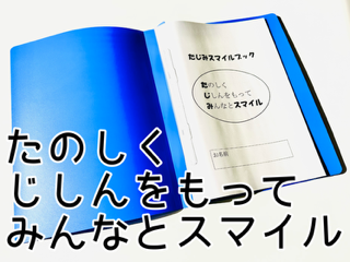 イラスト：楽しく、自信を持って、みんなとスマイル。青色のファイルにシートが綴じてあり「たじみスマイルブック」と書かれている。