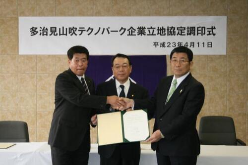 写真：三者で握手している様子