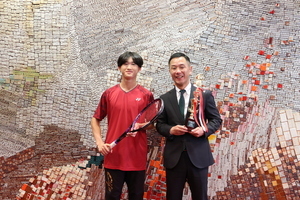 写真：ラケットを持った高尾さんとトロフィーを持った市長の写真