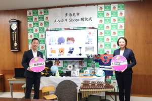 写真:メルカリ開設式で市長と佐々木参事が出品作品を手に持つ写真
