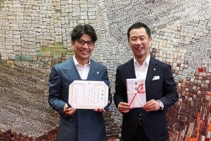 写真:目録と感謝状を手に写真撮影する富田社長と市長の様子