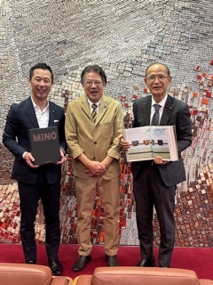 書籍を手に写真撮影をする笠井さんと市長、教育長