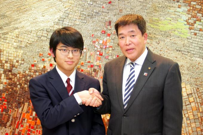 田中さんと市長が握手する様子