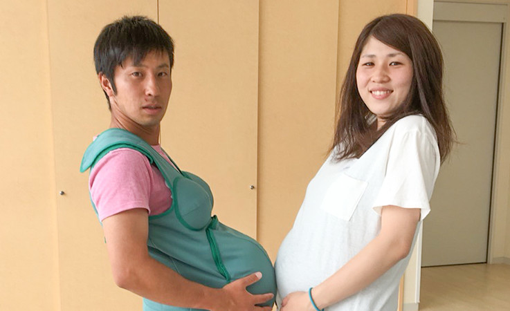 妊婦体験をしている佐治さん夫婦の写真